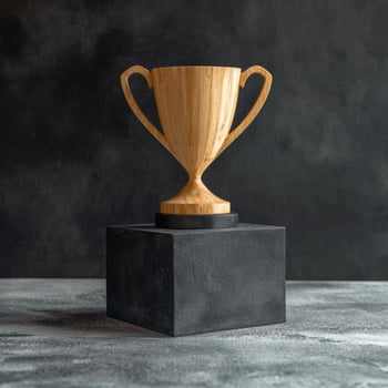 Wooden trophy on black cube pedestal photo