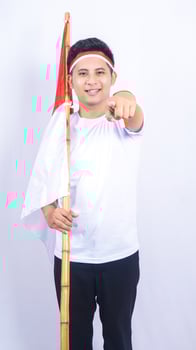 Indonesian Young Man Pointing at Camera while Holding Country Flag photo