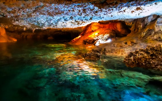Cenote Park Yaxmulito with lights limestone rocks turquoise water and nature. photo
