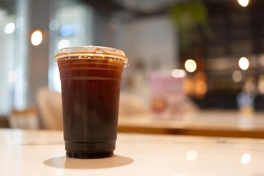 Black coffee with ice in a take away glass at cafe. photo