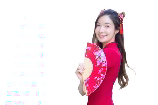 Young beautiful Asian female in red dress stands holds fan in while isolated white background Chinese new year theme. photo