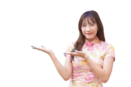 Young asian beautiful confident woman in pink dress stands is pointing hand to present something while isolated white background in Chinese new year theme. photo