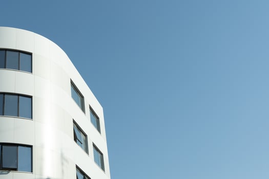 A white building with windows and a blue sky photo