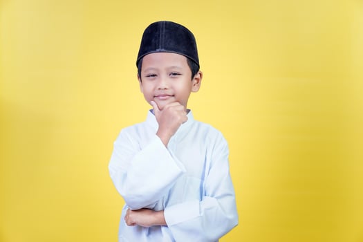 A thoughtful asian child in muslim attire, celebrating the spirit of Ramadan Kareem with joy. photo