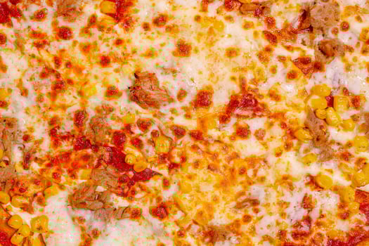 Delicious pizza topped with corn and meat, served fresh from the oven in a cozy kitchen photo