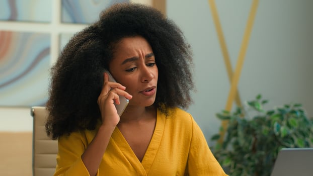 Dissatisfied annoyed African American businesswoman angry mad displeased office employer business woman girl female lady sad unhappy talk cellphone answer mobile phone call speak negative conversation photo