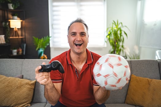Middle age Caucasian man playing soccer game at home photo