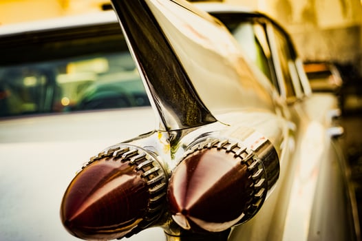 Stylized vintage photo of a retro car with wing brake lights. The brake light is close, and the photo is of an old car. High quality photo