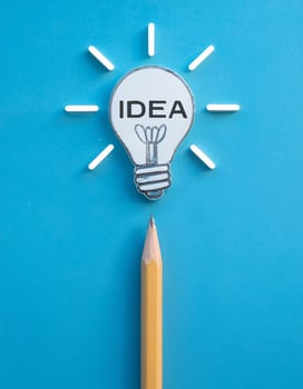 Inspiration and Innovation Concept with Pencil, Light Bulb, and 'Idea' Word photo