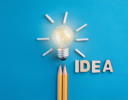 Creativity Concept with Light Bulb, Pencil, and 'Idea' Text on Blue photo