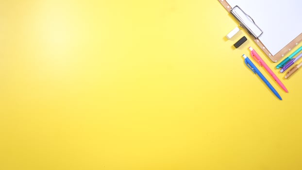 School Stationery and Wooden Clip Board on Yellow Background photo