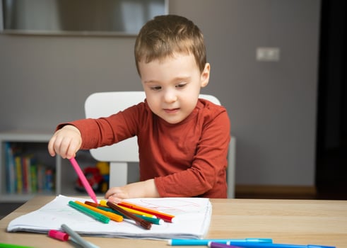 A cute little toddler boy of two years drawing photo