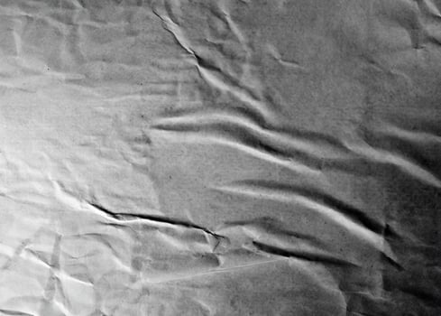 Grayscale wrinkled paper texture with folds and subtle creases, ideal for abstract and design projects. photo