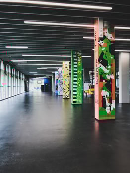 Long hallway with colorful pillars and a black floor photo