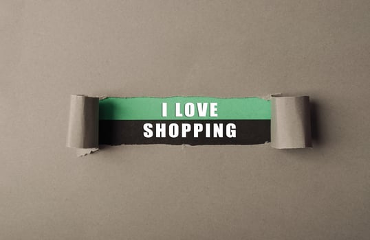 A torn piece of paper with the words I love shopping written on it photo