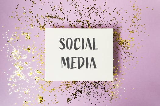 White card with gold glitter and the word social media written on it photo