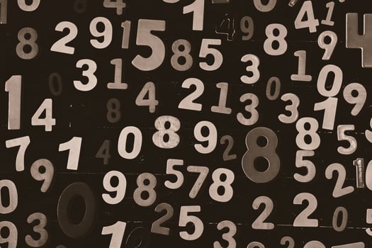 Numbers on a black wooden background, close-up, toned photo