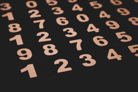 Wooden numbers on a black background. Numbers are laid out in the form of figures. photo