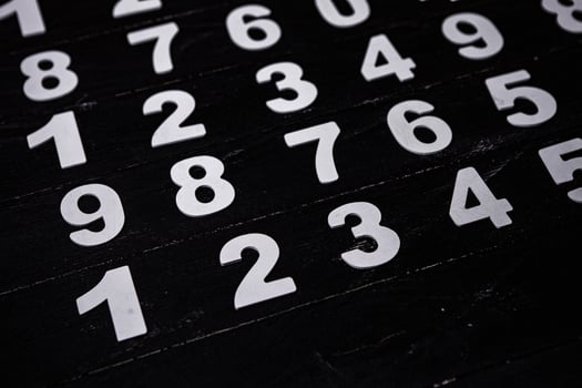 White numbers on a black background. Numbers scattered on the table. photo