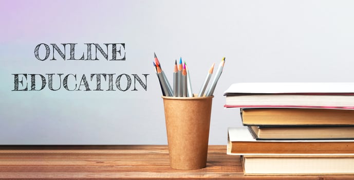 A wooden table with a cup of pencils and a stack of books photo