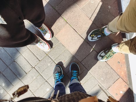 Group of people are standing on a brick sidewalk photo