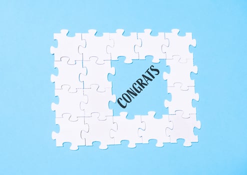 Jigsaw puzzle with the word congratulations written in the middle photo