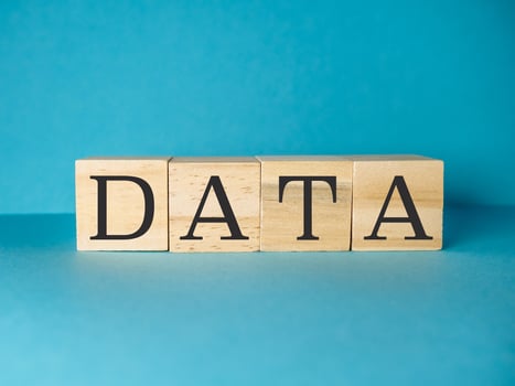 Wooden block with the letters DATA is on a blue background photo