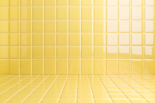 A bright yellow tiled wall and floor, creating a cheerful and clean aesthetic. photo