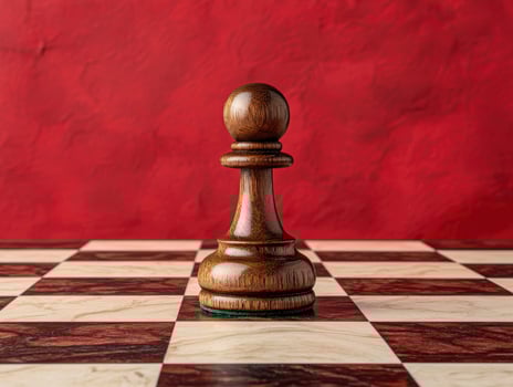 Single wooden chess pawn on a chessboard against a red background photo