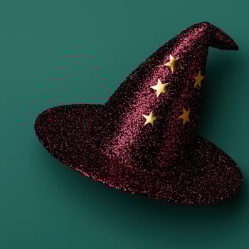 Red sparkly witch hat with gold stars on a dark green background photo