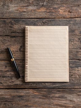 Blank notepad and pen on rustic wooden table photo