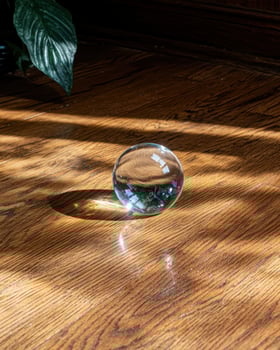 Glass sphere on wooden surface reflecting light photo