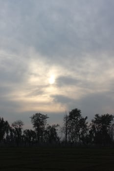 A cloudy sky with a sun shining through it photo