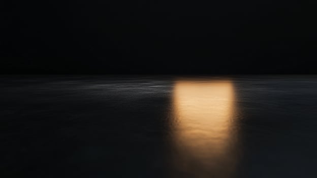 A dark, empty room with a small light shining on the floor photo