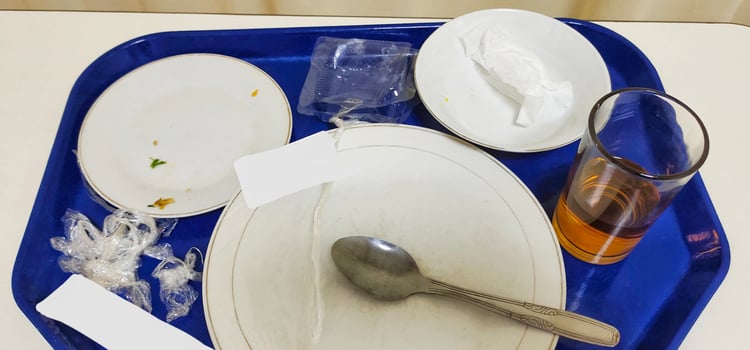 Portrait of dirty plates and glasses after serving hospital food, concept of patient after eating. photo