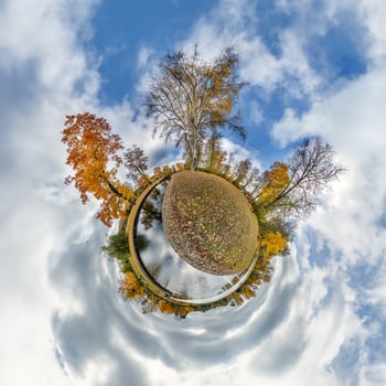 A small planet with trees and water in the sky photo