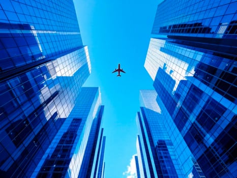 Airplane flying in the blue sky over skyscrapers in the city photo