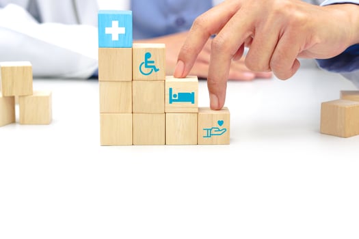 Two fingers of doctor is walking up stairs wooden blocks with medical symbol icons. Concept of Success, progress, medical and growth. photo