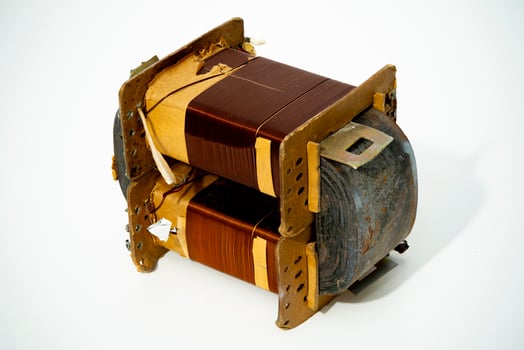 Detailed view of a vintage electrical transformer on a plain background photo