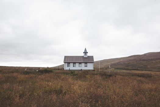 Quaint white church sits peacefully in a field photo