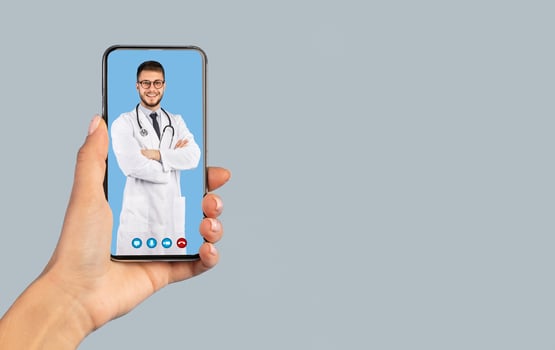 Medical Application. Female Hand Holding Smartphone With Male Doctor On Phone Screen Smiling To Camera Wearing White Uniform On Blue Studio Background. Distance Consultation. Vertical, Collage photo