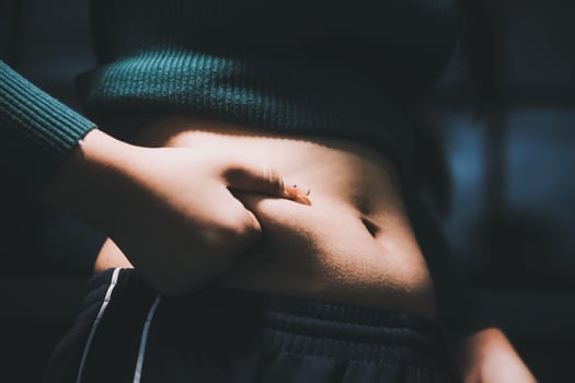 A woman is holding her stomach with her hands photo