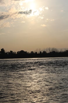 A boat is in the water with a cloudy sky photo