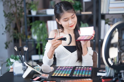 a woman is holding a makeup palette reviwing it photo