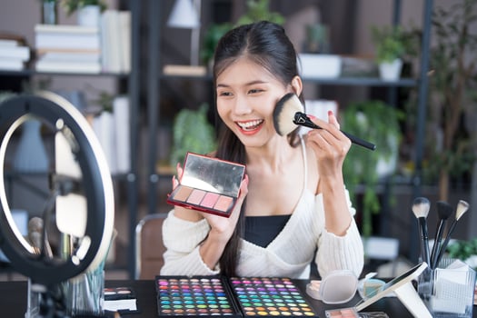 a woman is smiling while holding a makeup brush photo