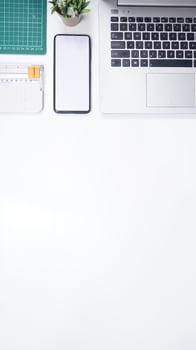 Modern Workspace with Laptop, Mobile Phone, and Work Tools on White Background photo