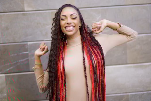 A Joyful and Cheerful Young Woman with Beautifully Braided Hair Posing Happily Outdoors photo