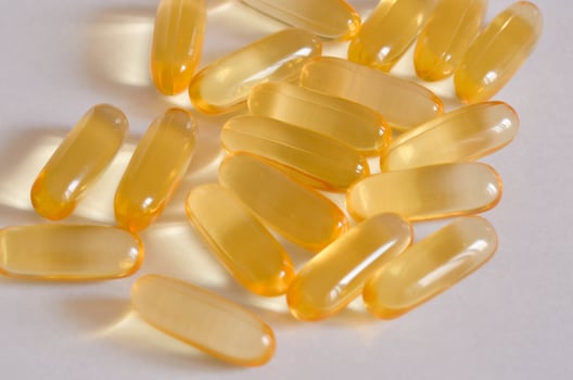 Transparent Softgel Capsules omega3 with Golden Hue on White Background photo