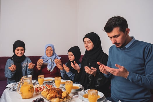 Muslim family making iftar dua to break fasting during Ramadan happy parents having dinner with their children and grandmother at dining table at home. photo