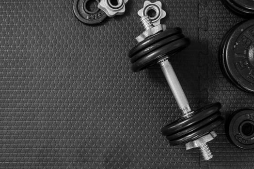 Top view of Iron dumbbells or weights on black floor with copy space for text photo